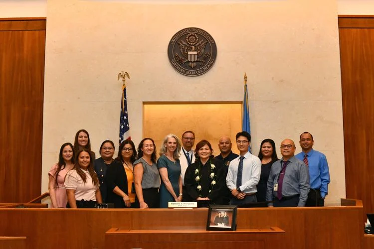 미국 NMI 지방법원의 라모나 V. 망로나(가운데) 부장판사는 어제 구알로라이에 있는 NMI 지방법원에서 10년 연임을 공식 선언함에 따라 헤더 L. 케네디 치안판사와 지방법원 직원들과 함께하고 있다.